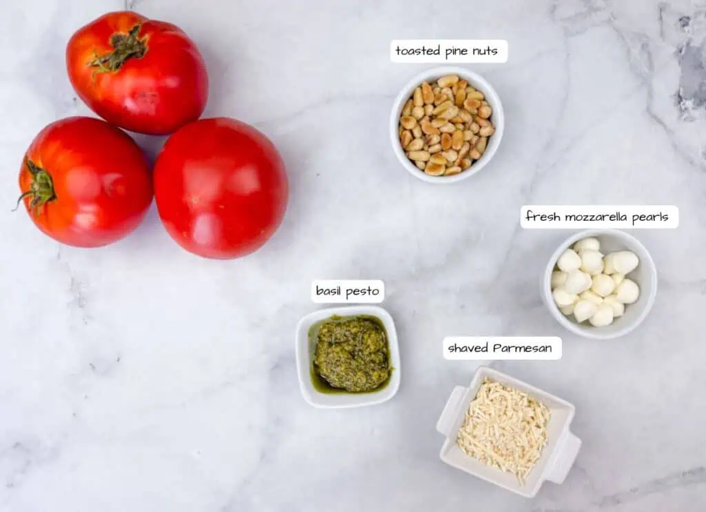 Tomatoes and nuts in bowls with pesto and mozzarella cheese.