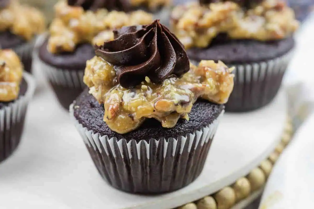 Close-up of German chocolate cupcake topped with coconut-pecan caramel and a swirl of chocolate buttercream.
