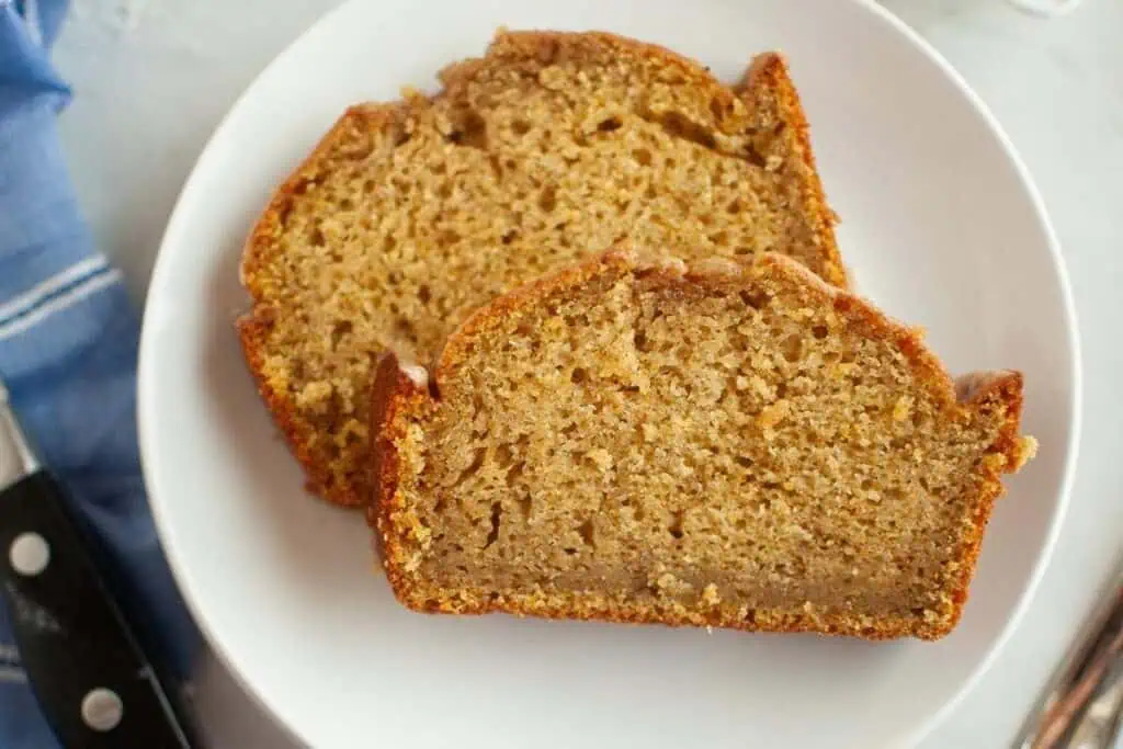 Two slices of banana bread on a white plate, viewed from above.