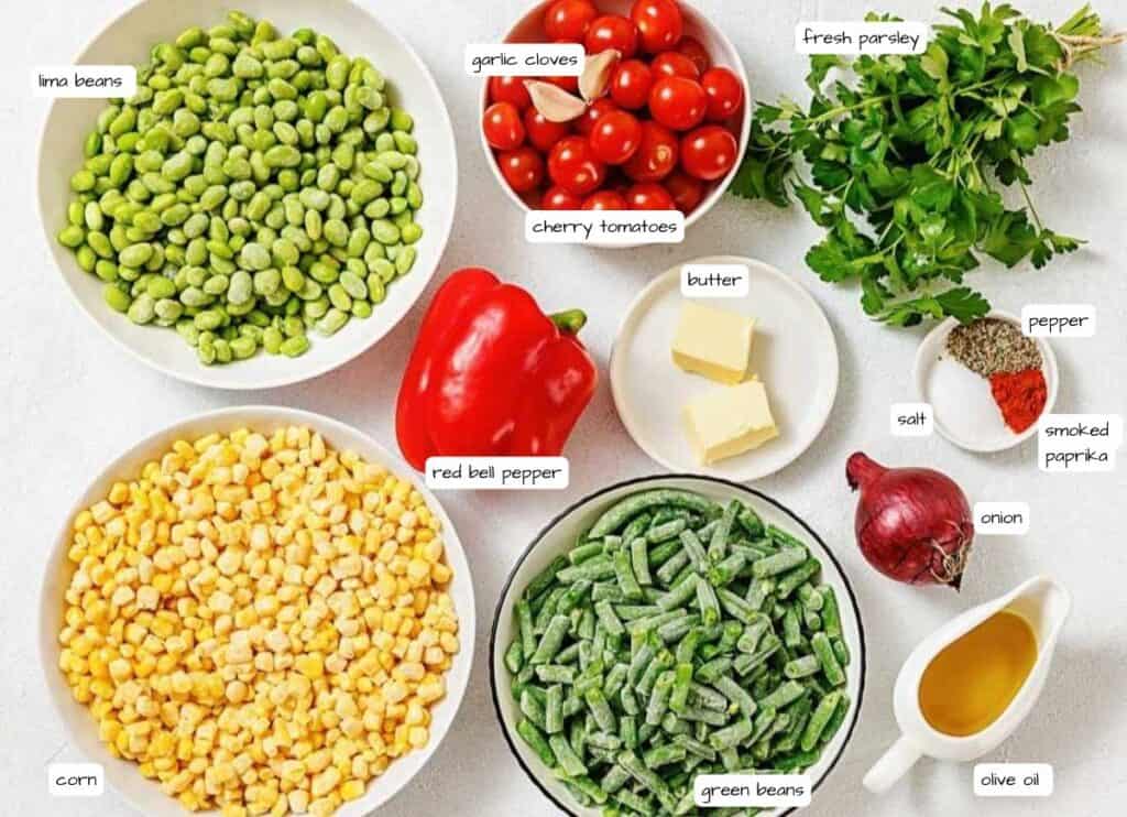 Bowls of lima beans, corn, green beans, cherry tomatoes, and labeled ingredients including red bell pepper, garlic cloves, fresh parsley, butter, onion, salt, smoked paprika, pepper, and olive oil.