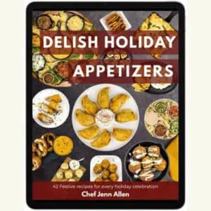 Tablet displaying the cover of "Delish Holiday Appetizers" by Chef Jenn Allen, featuring various appetizers and dips arranged around the title text.