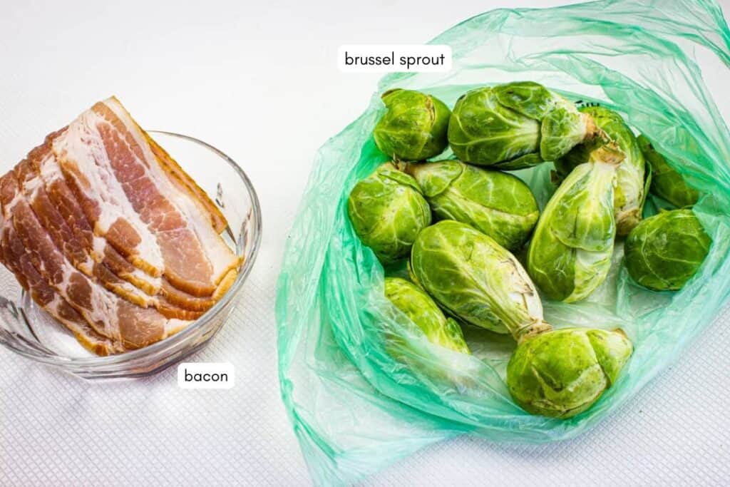 Slices of raw bacon in a glass bowl next to fresh brussels sprouts in a green plastic bag, both labeled.