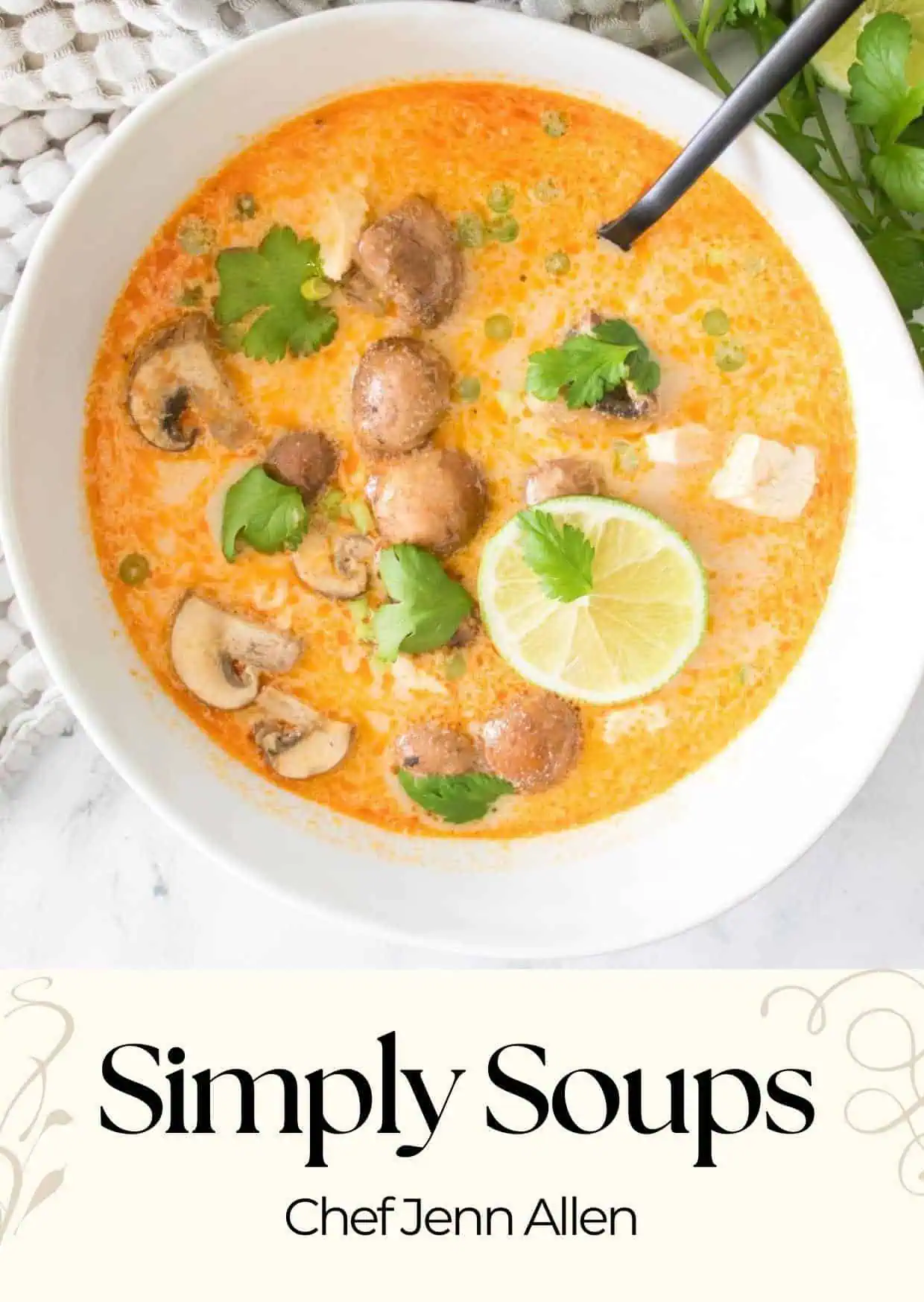A bowl of orange soup with mushrooms, cilantro, green onions, and a slice of lime, with a black spoon. Text at the bottom reads “Simply Soups Chef Jenn Allen.”.