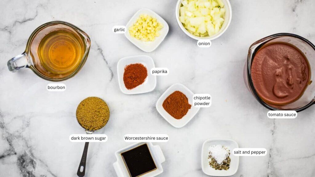 Ingredients for a sauce recipe arranged on a marble surface, including bourbon, tomato sauce, onion, garlic, paprika, chipotle powder, dark brown sugar, Worcestershire sauce, salt, and pepper.