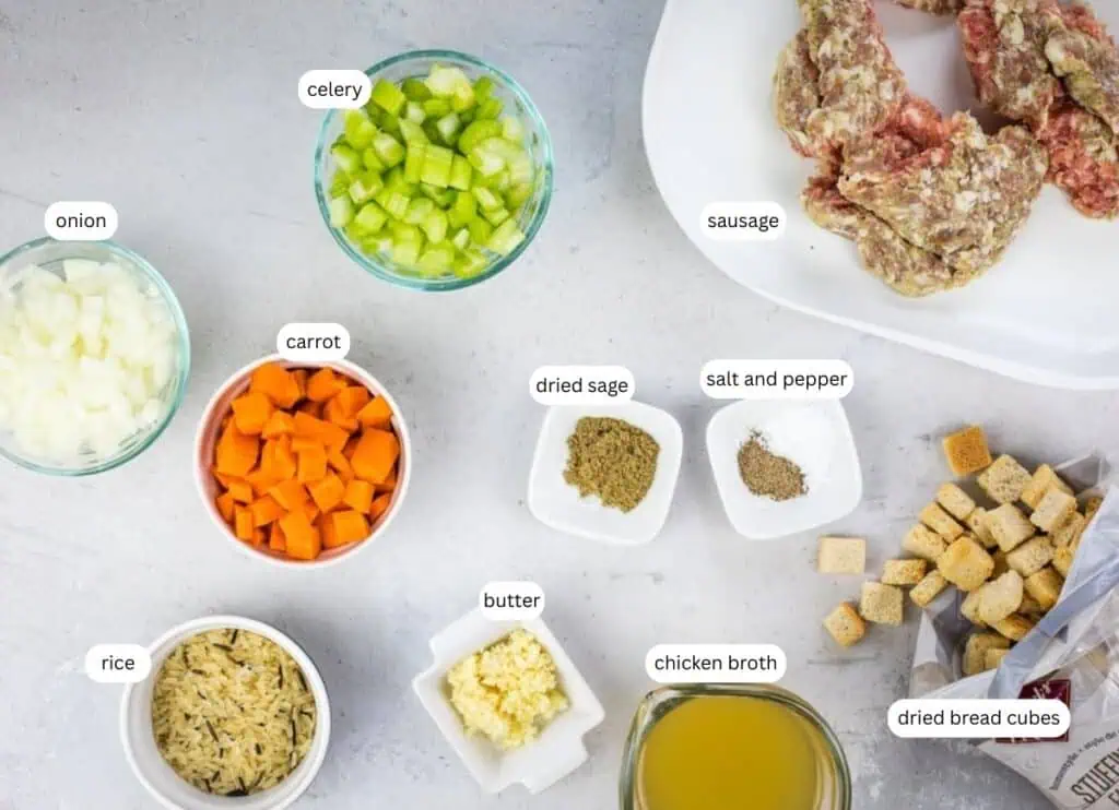 Various labeled ingredients for stuffing, including chopped onion, celery, carrot, rice, sausage, dried sage, salt, pepper, butter, chicken broth, minced garlic, and dried bread cubes.