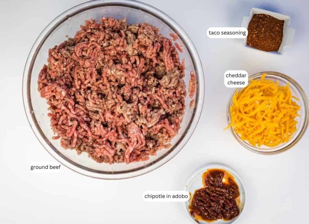 Four bowls containing ground beef, shredded cheddar cheese, taco seasoning, and chipotle in adobo, each labeled with text.
