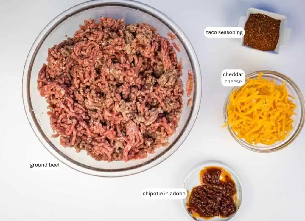 Four bowls containing ground beef, shredded cheddar cheese, taco seasoning, and chipotle in adobo, each labeled with text.