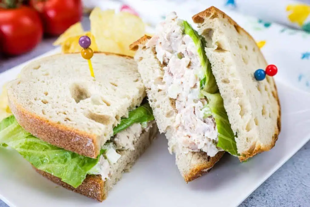 A sandwich filled with Costco chicken salad on a white plate.