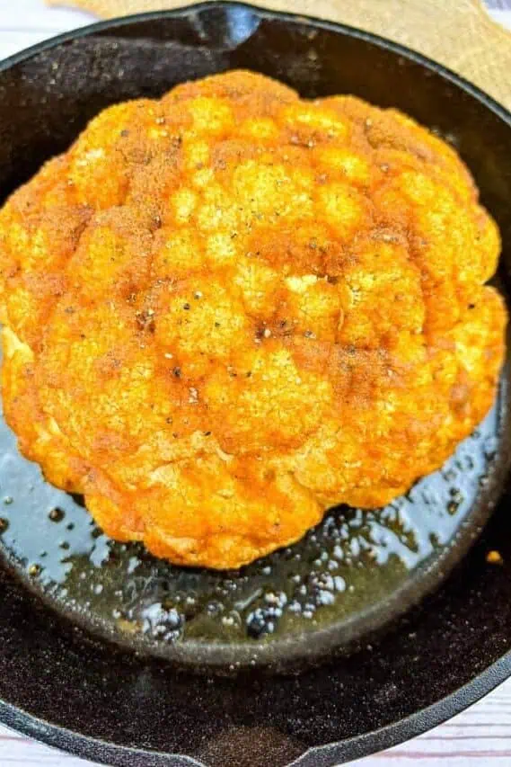 whole smoked cauliflower in a cast iron pan