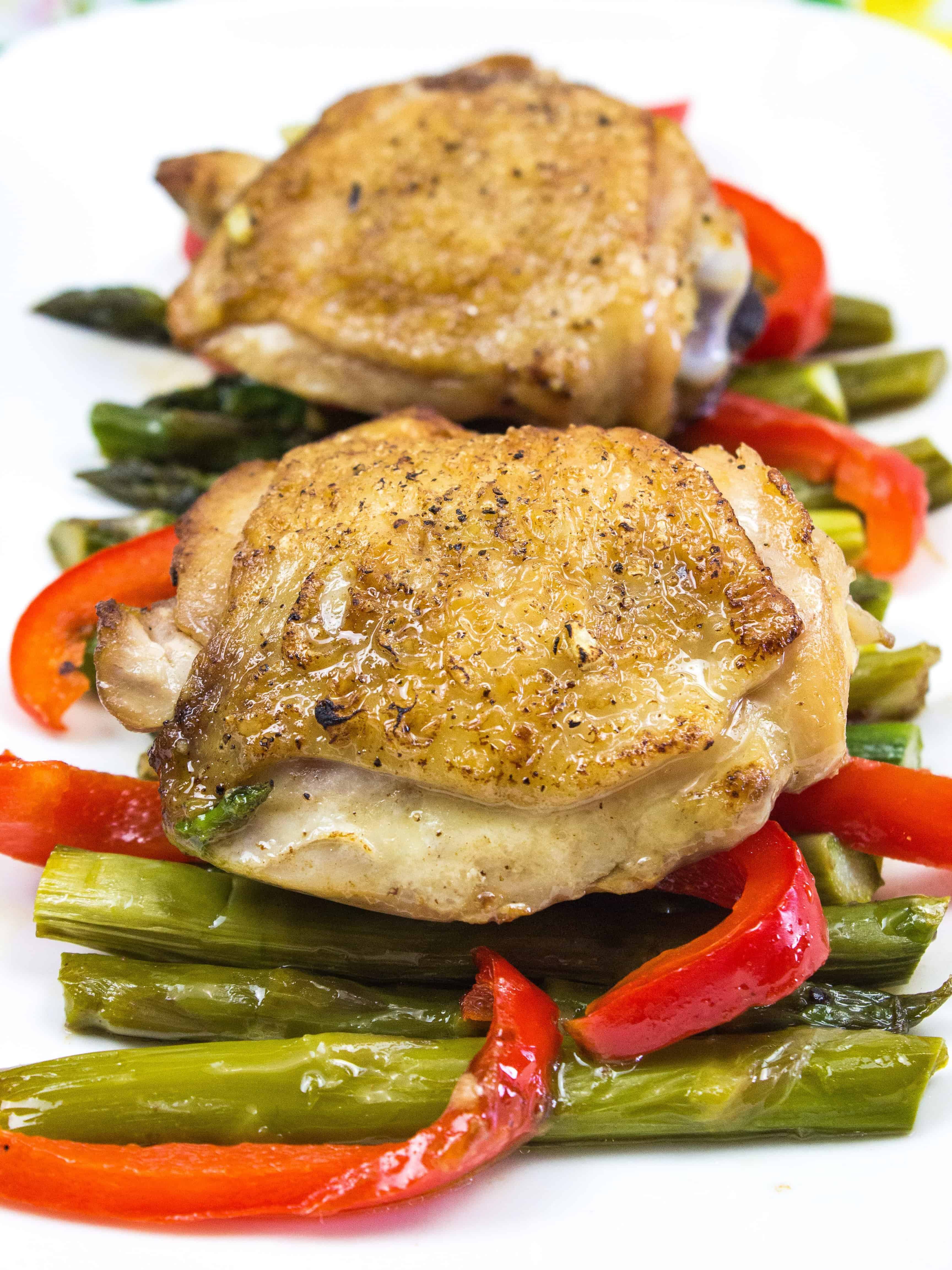 garlic chicken with asparagus on a white platter