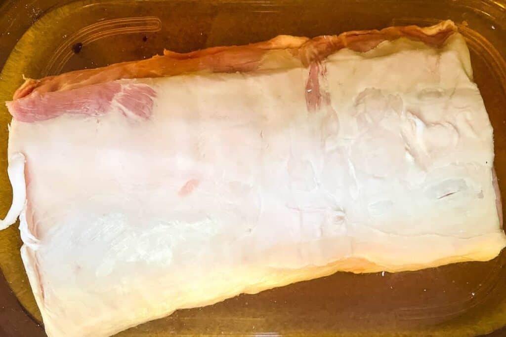 Raw pork loin in the brine in the fridge.