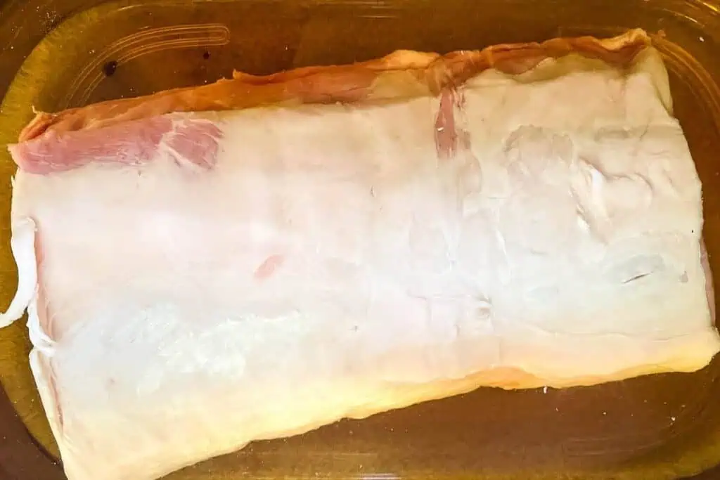 Raw pork loin in the brine in the fridge.