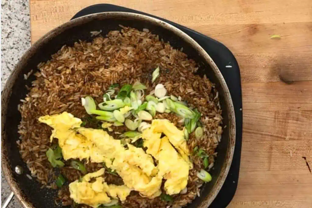 Add the butter, the green parts of the onions, and the scrambled egg back to the pan.