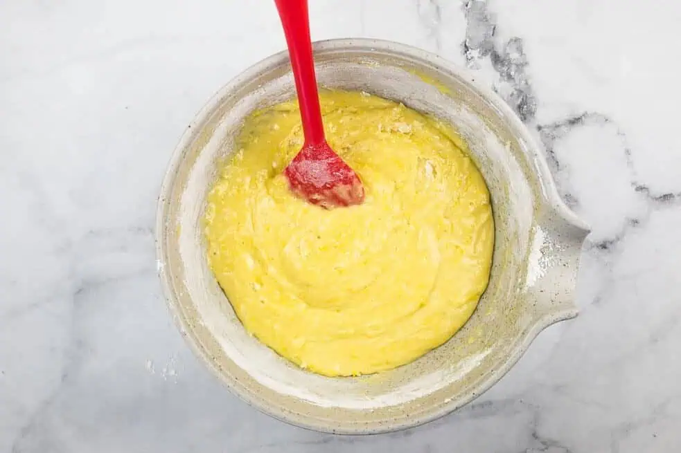 Lemon loaf batter mixed in a bowl with a spatula.